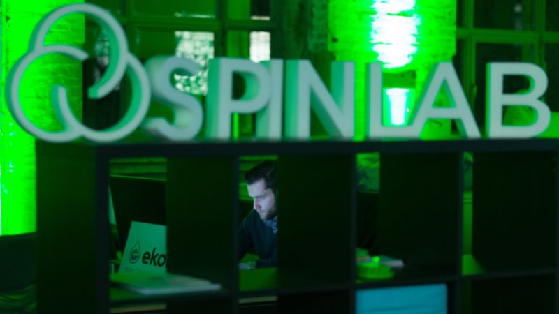A picture of the SpinLab office in the dark with green lights and a men working