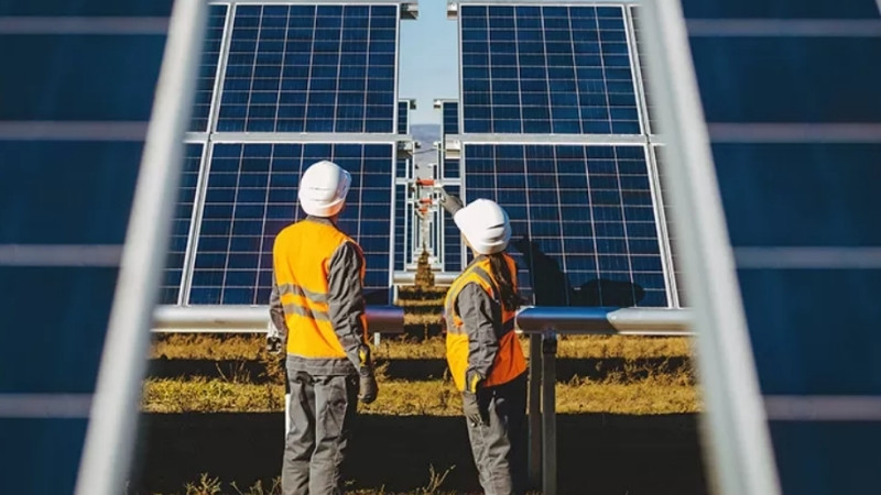 Picture of solar modules and two persons working