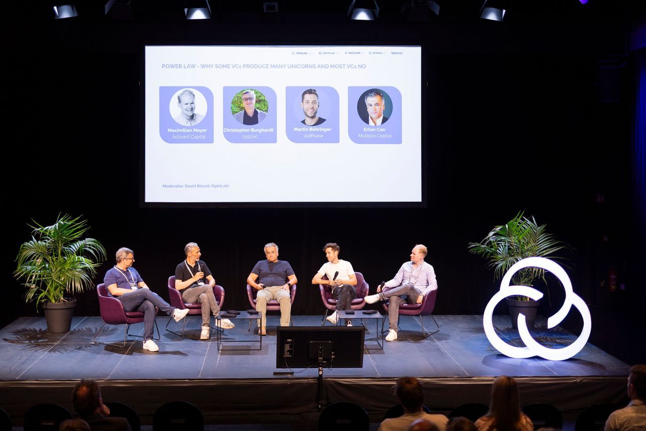 a photo of a stage with the 5 male panelists