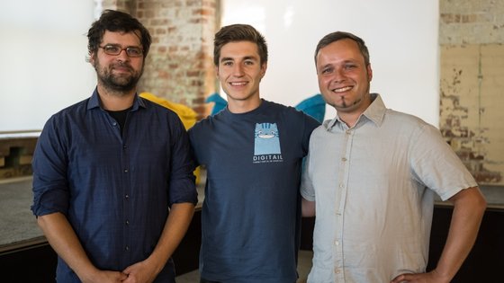 A photo of the Digitail startup team in the Leipzig SpinLab Office. 3 men smile.