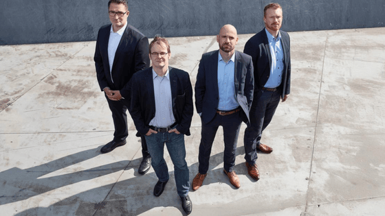 The founder of Flynex, 4 males wearing suit and looking into the camera. The photo was taken from above.