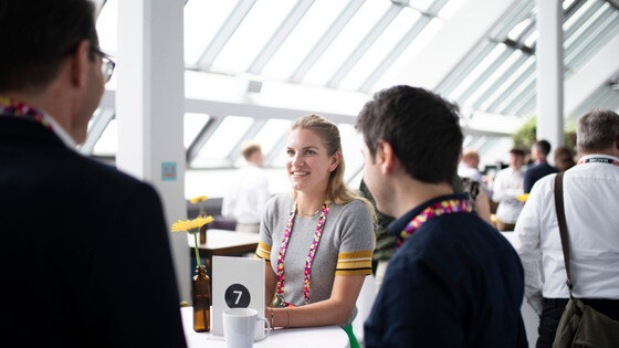 10 Startup Events in Europe You Should Not Miss in 2025. A women talking with two other people.