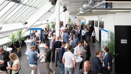 A photo of an event where people talking to each other in a foyer