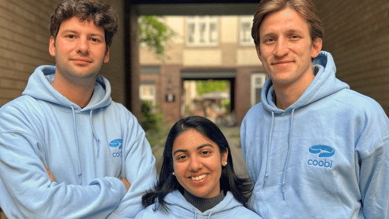 a team photo of the startup coobi, 2 men and one women wearing a blue sweater
