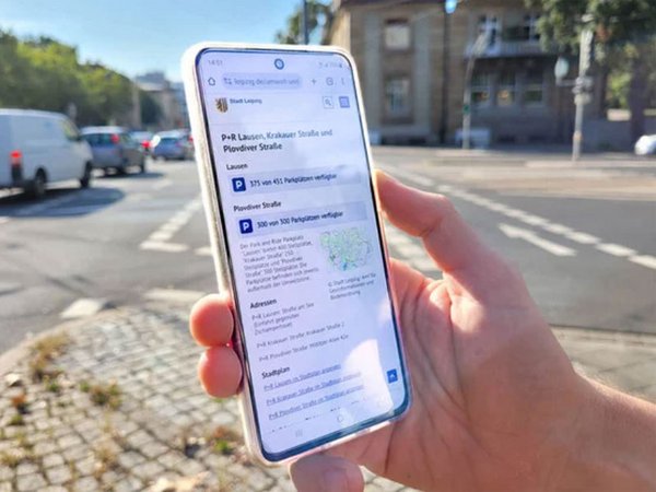Stadt Leipzig Mobile App Park and Ride: Someone is holding a smartphone in their hand, you can see the website of the city of Leipzig