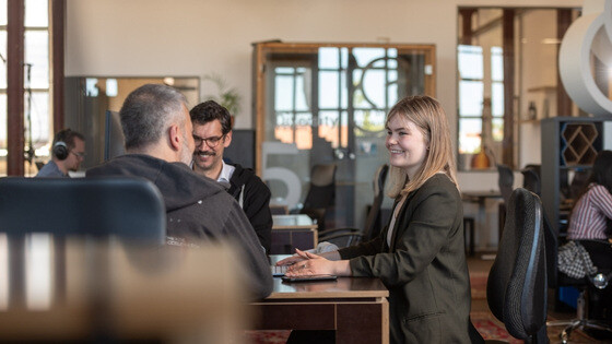 A group of people in the office talking to each other